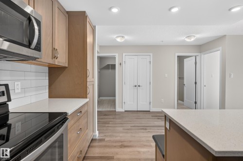 Stainless steel appliances, light wood-finish cabinetry, quartz countertops, white subway tile backsplash, and recessed lighting - #131 5504 Schonsee Dr Nw, Edmonton, AB - Indoor Photo Showing Kitchen
