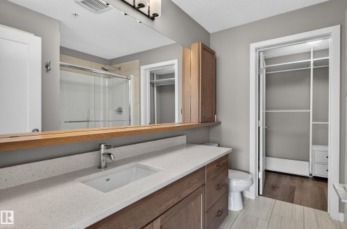 Spacious vanity with an integrated sink and light-toned countertop - #131 5504 Schonsee Dr Nw, Edmonton, AB - Indoor Photo Showing Bathroom