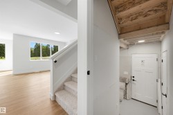 Wood-finish flooring, recessed lighting, and large windows illuminate the interior - 