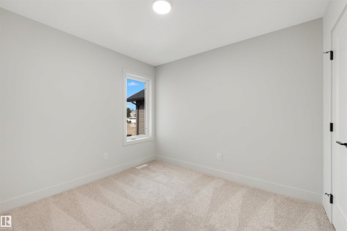 Recessed ceiling lighting, white interior door with black hardware, neutral wall color, single pane window, light carpet flooring - 16 Grayson Green, Stony Plain, AB - Indoor Photo Showing Other Room