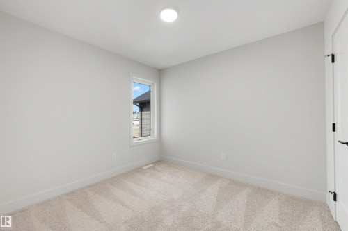 Recessed ceiling lighting, a single window, light-colored carpeting, and a white door with matte black hardware - 16 Grayson Green, Stony Plain, AB - Indoor Photo Showing Other Room
