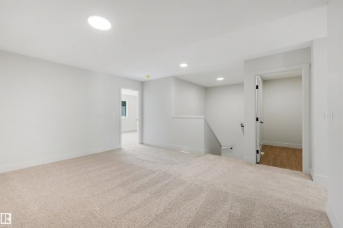 Recessed lighting, large circular ceiling light, carpeted flooring, white walls, interior doorway with wood-finish flooring beyond - 16 Grayson Green, Stony Plain, AB - Indoor Photo Showing Other Room