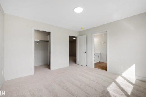 Wall-to-wall carpeting with light-toned walls, a built-in closet with shelving, and a round flush-mount ceiling light - 16 Grayson Green, Stony Plain, AB - Indoor