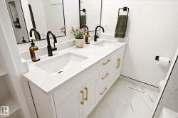 Dual vanity with integrated sinks, white cabinetry, gold-finish hardware, black-finish faucets, and patterned flooring - 