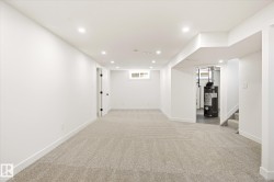 Finished lower level featuring recessed lighting, light-toned carpet, white walls, and a small window - 