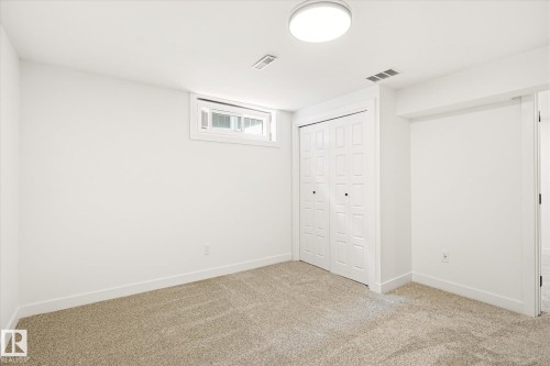 Bright room with carpet flooring, a window, bifold closet doors, and recessed lighting - 4708 104A Avenue Nw, Edmonton, AB - Indoor Photo Showing Other Room
