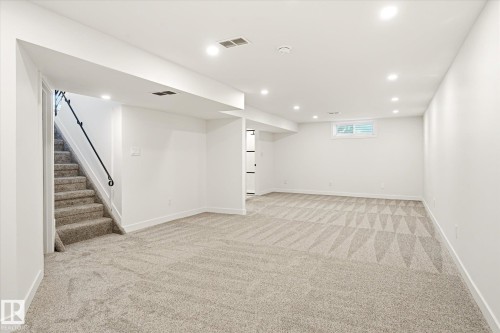 Spacious room featuring light-toned carpet flooring, white walls, and recessed lighting - 4708 104A Avenue Nw, Edmonton, AB - Indoor Photo Showing Other Room