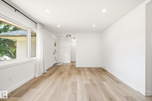 Open-concept room featuring wood-finish flooring, white walls, and recessed lighting - 4708 104A Avenue Nw, Edmonton, AB - Indoor Photo Showing Other Room