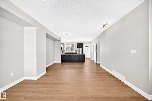 Wood-finish flooring throughout, light gray wall finishes, recessed lighting, and track lighting fixtures - #75 2803 James Mowatt Tr Sw, Edmonton, AB 