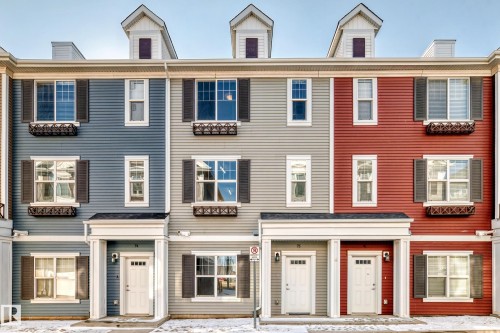 Vertical siding exterior with multiple window styles, decorative window boxes, dormer architectural features, and individual entryways - #75 2803 James Mowatt Tr Sw, Edmonton, AB 