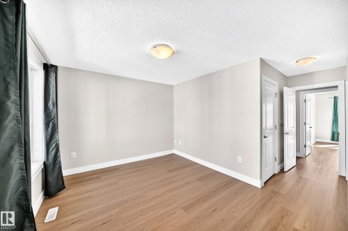 Wood-finish flooring, white trim, and neutral wall paint - #75 2803 James Mowatt Tr Sw, Edmonton, AB 