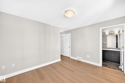 Wood-finish flooring, white trim, and light gray walls - #75 2803 James Mowatt Tr Sw, Edmonton, AB 