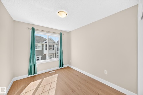 Wood-finish flooring, neutral wall paint, and a ceiling-mounted light fixture - #75 2803 James Mowatt Tr Sw, Edmonton, AB 