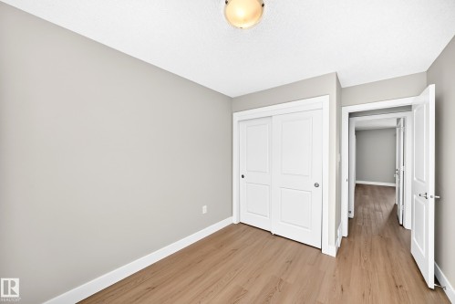 Wood-finish flooring, white sliding closet doors, ceiling-mounted lighting fixture, and light-toned walls - #75 2803 James Mowatt Tr Sw, Edmonton, AB 