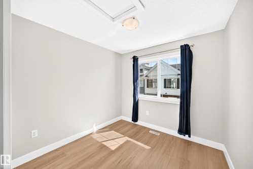 Wood-finish flooring, white trim, and a window with a white frame - #75 2803 James Mowatt Tr Sw, Edmonton, AB 