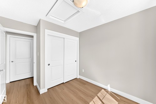 Wood-finish flooring, white trim, light gray walls, and white panel doors - #75 2803 James Mowatt Tr Sw, Edmonton, AB 