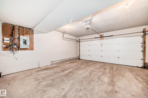 Automated garage door with track system and opener - #75 2803 James Mowatt Tr Sw, Edmonton, AB 