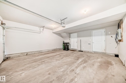 Concrete flooring, white walls, two white panel doors, and overhead lighting - #75 2803 James Mowatt Tr Sw, Edmonton, AB 