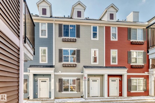 Multi-level townhome exterior with dormer windows, shuttered windows, and decorative window boxes - #75 2803 James Mowatt Tr Sw, Edmonton, AB 