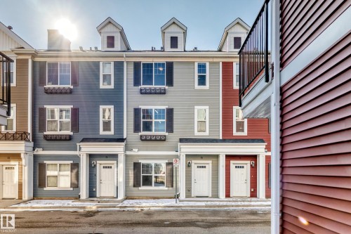 Multi-story townhome with dormer windows, shuttered windows, and a portico entrance - #75 2803 James Mowatt Tr Sw, Edmonton, AB 