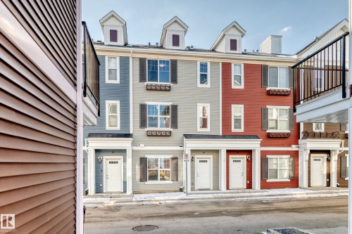 Townhome exterior with varied siding colors, multiple windows, decorative shutters, and dormer windows - #75 2803 James Mowatt Tr Sw, Edmonton, AB 