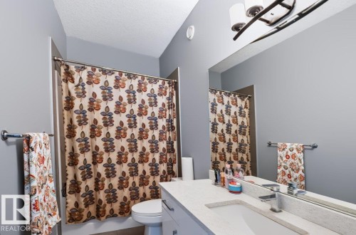 Single vanity with an integrated rectangular sink, chrome-finish faucet, and a large wall-mounted mirror - 527 Merlin Landing Nw, Edmonton, AB - Indoor Photo Showing Bathroom