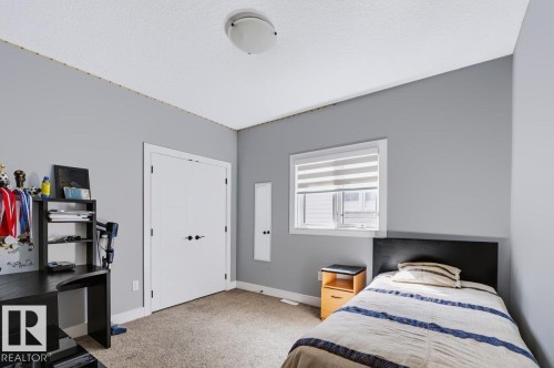 Recessed window with horizontal blinds, double-door closet, and overhead flush-mount lighting - 527 Merlin Landing Nw, Edmonton, AB - Indoor Photo Showing Bedroom