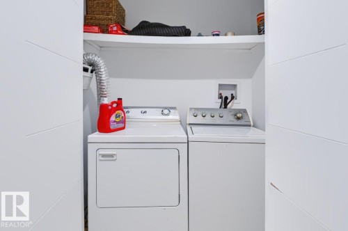 Laundry area with a washer and dryer and an integrated storage shelf - 527 Merlin Landing Nw, Edmonton, AB - Indoor Photo Showing Laundry Room