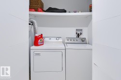 Laundry area with a washer and dryer and an integrated storage shelf - 