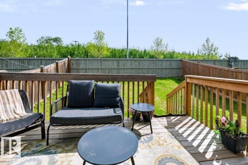 Spacious wood deck with railing, stairs leading to a grassy yard, and a privacy fence - 527 Merlin Landing Nw, Edmonton, AB - Outdoor With Deck Patio Veranda