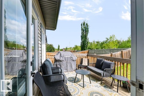 Expansive outdoor deck with wood-finish railing, wood-tone flooring, and direct access from the interior - 527 Merlin Landing Nw, Edmonton, AB - Outdoor With Exterior