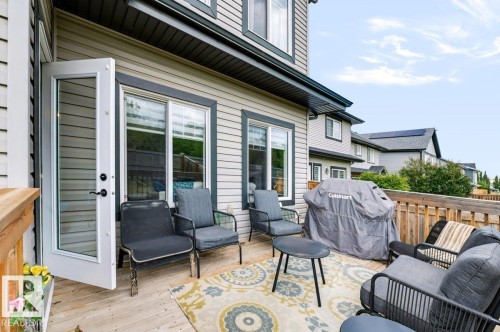Spacious wooden deck with railing, featuring double glass-paneled doors, and exterior siding - 527 Merlin Landing Nw, Edmonton, AB - Outdoor With Deck Patio Veranda With Exterior
