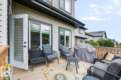 Spacious wooden deck with railing, featuring double glass-paneled doors, and exterior siding - 