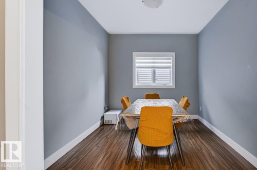Wood-finish flooring with white trim, a single window with blinds, and a flush-mount ceiling light - 527 Merlin Landing Nw, Edmonton, AB - Indoor Photo Showing Dining Room