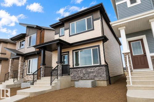 Contemporary exterior with contrasting siding, black-framed windows, stone accent detailing, and covered entry - 219 157 Avenue Ne, Edmonton, AB - Outdoor