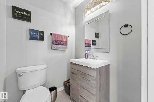 Modern vanity with a white countertop and integrated sink, chrome faucet, and rectangular framed mirror - 11119 31St Nw Nw, Edmonton, AB - Indoor Photo Showing Bathroom