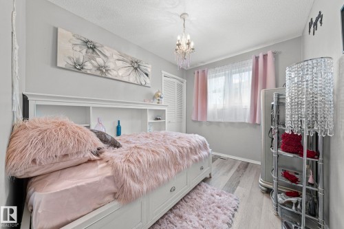 Light gray wall color, wood-finish flooring, and a crystal chandelier - 11119 31St Nw Nw, Edmonton, AB - Indoor Photo Showing Bedroom
