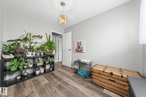 Wood-finish flooring with a neutral wall color, featuring a semi-flush mount ceiling fixture - 11119 31St Nw Nw, Edmonton, AB - Indoor Photo Showing Other Room