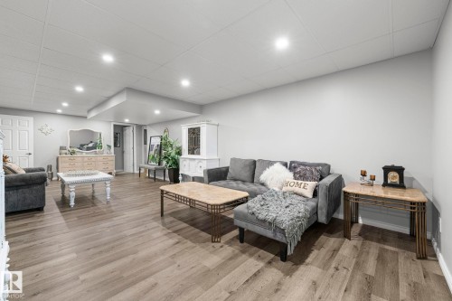 Spacious room featuring wood-finish flooring, recessed lighting, and light gray walls - 11119 31St Nw Nw, Edmonton, AB - Indoor