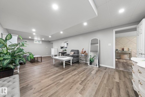 Spacious room featuring recessed lighting, wood-finish flooring, light grey wall paint, and a white interior door - 11119 31St Nw Nw, Edmonton, AB - Indoor