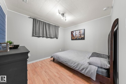 Light gray walls with wood-finish flooring - 11119 31St Nw Nw, Edmonton, AB - Indoor Photo Showing Bedroom