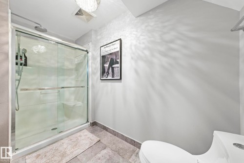 Glass-enclosed shower with a rainfall showerhead, white tile surround, and built-in bench - 11119 31St Nw Nw, Edmonton, AB - Indoor Photo Showing Bathroom