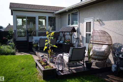 Outdoor living area featuring a wood deck, built-in planter box, and sunroom with sliding glass doors - 11119 31St Nw Nw, Edmonton, AB - Outdoor With Deck Patio Veranda