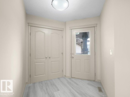 Wood-finish flooring, paneled doors, and a ceiling-mounted light fixture - 3010 17A Ave Nw, Edmonton, AB - Indoor Photo Showing Other Room