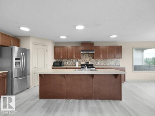 Wood-finish flooring, recessed lighting, and a kitchen island with a double basin sink - 3010 17A Ave Nw, Edmonton, AB - Indoor Photo Showing Kitchen