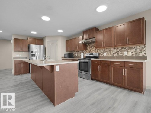 Kitchen featuring wood-finish flooring, recessed lighting, and a center island with a sink - 3010 17A Ave Nw, Edmonton, AB - Indoor Photo Showing Kitchen With Upgraded Kitchen