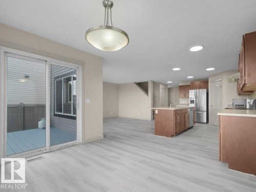 Open-concept living space with wood-finish flooring, recessed lighting, and a sliding glass door to an outdoor deck - 3010 17A Ave Nw, Edmonton, AB - Indoor Photo Showing Kitchen