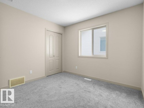 Neutral wall paint, light gray carpeting, bi-fold closet doors, and a window with white trim - 3010 17A Ave Nw, Edmonton, AB - Indoor Photo Showing Other Room