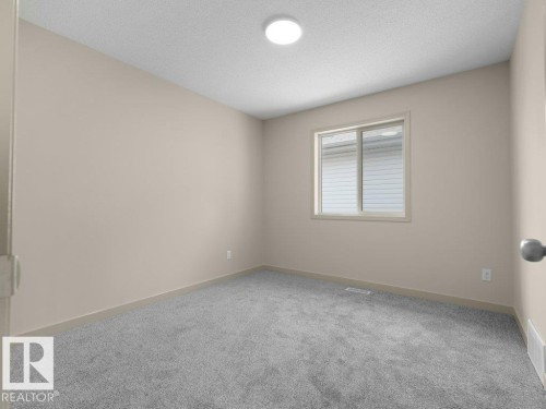 Neutral-toned walls, grey carpeting, and a flush-mount ceiling light fixture - 3010 17A Ave Nw, Edmonton, AB - Indoor Photo Showing Other Room