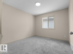 Neutral-toned walls, grey carpeting, and a flush-mount ceiling light fixture - 